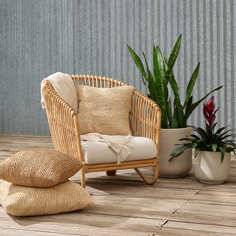 Ceramic planters next to rattan lounge chair, natural